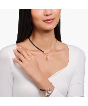 Thomas Sabo Silver Charm Necklace. Member Charm Necklace featuring Dark Blue Beads and a captivating Charmista Disc. This necklace offers a truly captivating aesthetic, seamlessly blending a link chain with an imitation sandstone beaded necklace in a mesmerizing dark blue hue. The centerpiece of this piece is the round THOMAS SABO Charm Club Charmista coin, meticulously hand-painted with dark blue cold enamel, adding an intriguing touch to your ensemble. The attention to detail is evident in the elaborately designed end caps featuring finely engraved lines. Material: 100% Sterling Silver. Ref: KE218900732.