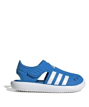 Juniors adidas Closed Toe Water Sandals in blue.- EVA upper.- Hook-and-loop adjustable bandage wings.- Closed toe with quick-dry openings.- Cushioned midsole.- Regular fit.- Textured outsole.- Ref: GW0385