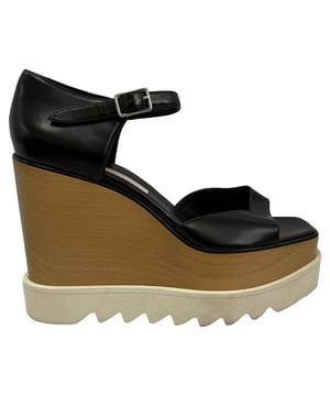 VINTAGE, RRP AS NEW
Make every step a statement with the Stella McCartney Elyse Wedge Sandals — a modern icon reimagined in sleek, cruelty-free black faux leather. Featuring an open round toe, adjustable ankle strap, and natural wood platform with a signature treaded foam sole, these sandals combine conscious luxury with architectural edge. Silver-tone hardware and tonal stitching add refined detail to this standout silhouette.

Stella McCartney Platform Elyse Wedge Sandals in Black Leather 
Condition: good
Signs of wear: Lightly used but very well maintained. Minor mark at soles & creasing, light scuffing at the soles and heels.
Packaging: None
Color: black
Material: Leather | leather
Size: EU | 39
Measurements: Heel height: 120 mm; Insole length: 245 mm
SKU: TONPUGBSH561530W