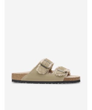 Birkenstock incorporate eco-friendly materials into their sustainable abstracts. These Arizona shearling suede sandals in beige capture the German label's preference for sturdy, innovative designs. They showcase an anatomically shaped cork-latex footbed. There are two straps, each with an individually adjustable metal pin buckle and colour-coordinated footbed.

Made in Germany
Suede Uppers
Shearling Footbed
EVA Sole