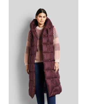 Die lange Weste im asymmetrischen Stil mit Kapuze ist aus einer versteppten sowie recycelten Qualität. Die Jacke lässt sich mit Druckknöpfen verschließen. Details und Innenleben sind edel abgestimmt und setzen dezente Akzente. Für eine ideale Wärmeisolation sorgt die Füllung; die auf nachwachsenden Rohstoffen basierende Faser.