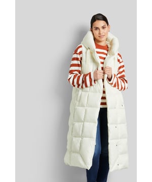 Het lange vest in asymmetrische stijl met capuchon is gemaakt van een gewatteerde en gerecyclede stof. Het vest sluit met drukknopen. De details en binnenkant zijn elegant op elkaar afgestemd en zorgen voor subtiele accenten. De vulling zorgt voor ideale warmte-isolatie; de vezel is gebaseerd op hernieuwbare grondstoffen.