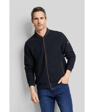 Diese sportliche Sweatshirtjacke besteht aus einem pflegeleichten Baumwoll-Elasthan-Mix und weist eine einfarbige 3-D-Struktur auf. Die Jacke besitzt außerdem Nylon-Details am Kragen und an der Tasche. Ein Collegekragen und praktische Eingrifftaschen runden das Design ab.