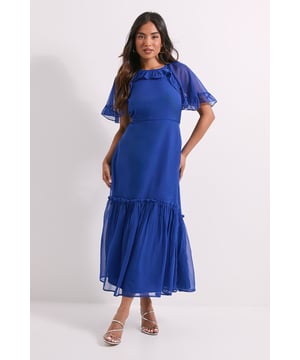 Delicate chiffon midi dress with elegant tiered design for added movement         Feminine frill cape sleeves with sheer overlay for a graceful silhouette         Flattering crew neckline adorned with subtle ruffle detailing         Tiered skirt construction creates a flowing, romantic effect         Petite fit designed specifically for smaller frames
    
    This charming Dorothy Perkins midi dress combines effortless style with practical comfort. The delicate chiffon fabric drapes beautifully across the body, while the tiered design adds dimension and movement to your silhouette. The cape sleeves with frill detailing offer just the right amount of coverage whilst maintaining a feminine aesthetic. Perfect for casual gatherings, this versatile piece can be styled with flat sandals and a woven bag for a relaxed brunch with friends, or paired with metallic accessories for baby showers and family celebrations. The midi length provides a modest yet contemporary look that's ideal for daytime events. Complete your ensemble with simple hoop earrings and a delicate bracelet for a polished finish that reflects your refined taste without overwhelming the dress's natural charm.
