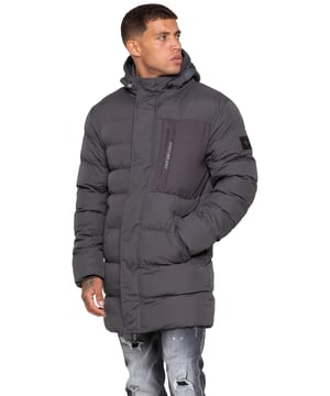 Stay warm and protected with the Enzo Milano Men’s Longline Puffer Jacket, crafted from smooth water-resistant poly fabric and insulated with synthetic fill for lasting comfort. Designed with a detachable faux fur trim and a faux fur-lined hood. The chest print and signature metal badge on the arm add premium detailing, while multiple zip pockets – including waist, chest, and inner options – keep your essentials secure. A drawcord hood with adjustable toggle, ribbed cuffs, and a full zip fastening with popper buttons provide extra protection against wind and rain, making this longline puffer your ultimate cold-weather essential.