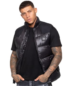 Elevate your outerwear with the Enzo Milano Men’s Puffer Gilet, designed for both style and practicality. Featuring an embroidered Enzo Milano logo on the zip guard and a sleek metal badge on the chest, this gilet delivers a touch of luxury. Built with functionality in mind, it includes two secure side zip pockets and a single inside zip pocket to keep your essentials safe. The drawcord hem with an adjustable toggle ensures a personalised fit, while the shiny finish gives it a modern, standout look.
