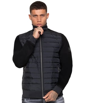 Step up your outerwear with the Enzo Milano Men’s Hybrid Jacket. Featuring a ribbed funnel neck collar and a padded, water-resistant poly front panel. The cotton jersey back panel and sleeves ensure flexibility and breathability, while ribbed cuffs and hem create a secure fit. Practical details include two side zipped pockets and inside storage options. Finished with the signature Enzo Milano metal badge on the left arm.