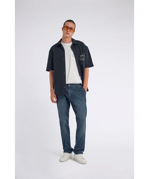 Denim-Chino in schmaler Passform, hergestellt aus blauem Indigo-Stretchstoff (8,70 OZ) und mit einer dunkelblauen Grundwaschung versehen. Ein unverzichtbares Kleidungsstück, das lässige Eleganz und tadellosen Komfort vereint und sich perfekt für vielseitige und anspruchsvolle Looks eignet. Hauptmerkmale: Passform: Slim Stoff: Stretch Blau Indigo 8.70 OZ Waschung: Basic dunkelblau