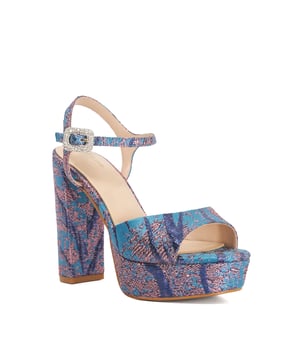 A show-stopping statement heel, Maycie brings bold colour and elevated glamour in one confident step. Set on a chunky platform with a sturdy block heel, this open-toe style is wrapped in vibrant pink and blue fabric. The signature solitaire buckle and adjustable ankle strap add both sparkle and support'perfect for occasions that call for standout style.