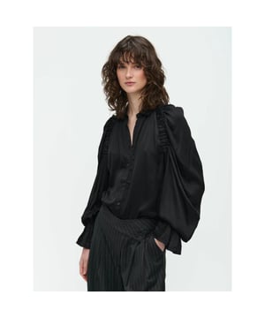 
Stap in de schijnwerpers met de Mima Blouse uit de collectie van Jane Lushka, een prachtig stuk gemaakt van glanzende viscose dat het licht vangt bij elke beweging. Deze blouse combineert een strakke, fashion-forward stijl met het luxueuze gevoel van viscose, waardoor het een perfecte keuze is voor zowel overdag als 's avonds.

 Productgegevens

  
 * Materiaal: 100% viscose 
 * Gemaakt in Europa 
 * Sluiting: geknoopte voorkant 
 * Reglan mouw met elastiek  Maat & pasvorm

  
 * Exact op maat 
 * Niet-elastische stof 
 * Relaxte pasvorm 
 * Het model op de foto is 178cm-5'10" en draagt maat S.