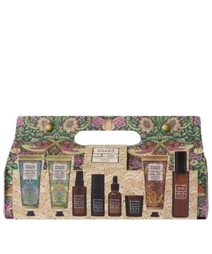 Strawberry Thief tool-bag containing eight boxed William Morris At Home self-care and home-fragrance items: Body & Room Mist 100ml, Pillow Mist 50ml, Hand Cream 100ml, Body Oil 30ml, Recovery Balm 100ml, Hair Mist 35ml, Candle 30g and Body Wash 100ml. Key scents include Green Davana, Clementine & Clove, Beautiful Sleep, Patchouli & Red Berry and Citronella Grass. Sustainably packaged, cruelty free and vegan. A portion of proceeds supports the William Morris Gallery.