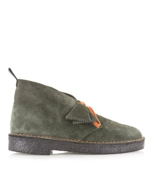 
<p>De Desert Boot Loden Green Suede van Clarks is een bijzondere uitvoering van herenschoenen die vakmanschap, geschiedenis en eigentijdse stijl samenbrengt. Deze heren veterschoenen in een verfijnde groene tint zijn gemaakt van hoogwaardig suède, wat zorgt voor een luxe en natuurlijke uitstraling.</p>
<p>Deze nette schoenen maken deel uit van de 75th Anniversary Edition, een eerbetoon aan 75 jaar iconische stijl van Clarks. Elke schoen is voorzien van twee exclusieve FOBs: één met het Clarks Originals-logo en een herdenkingsvariant met de opdruk “Desert Boot since 1950”. Voor extra veelzijdigheid bevat dit jubileummodel twee sets veters; een opvallende iconische oranje variant en een tonale platte veter voor een meer ingetogen look.</p>
<p>De metalen tonale veteroogjes en het speciale geweven label op de tong onderstrepen het premium karakter van deze uitvoering. Het geheel wordt afgewerkt met een zwart treklipje waarop "C&J Clarks LTD Est 1825" is gedrukt; een subtiele verw