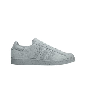 Y-3 Superstar Trainers in helder onix. De iconische Superstar schoenen zijn ongetwijfeld een van de meest gevierde sneakers van adidas en krijgen een update van Y-3. De schoenen hebben een knipoog naar de Japanse techniek van Sashiko stiksels. Met een knipoog naar de Japanse techniek van Sashiko stiksels hebben de sneakers geaccentueerde en ton-sur-ton stiksels rond de eyestay hiel tab tussenzool en de kenmerkende 3-Stripes met alle draden opzettelijk losjes hangend. Het suède bovenwerk en de middenzool creëren een illusie van beton door de sproeterige details rond het bovenwerk en de middenzool. Y-3's versie van de adidas Superstar schoenen is geïnspireerd op traditionele Sashiko stiksels. - Vetersluiting.- Suède bovenwerk.- Leren en canvas voering.- Y-3 logo.- Rubberen zool.- Suède bovenwerk Leren en textielen voering Synthetische zool.- Ref: IG3043