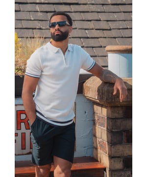 Elevate your smart-casual style with this polo from Brave Soul, designed with a sleek concealed 1/4 zip neck fastening for a clean, contemporary finish. Made from an all-over rib knit fabric, this polo offers a comfortable stretch fit with refined texture. Contrast stripe trims at the collar and cuffs add a pop of detail, to this elevated everyday essential. Model wears UK size M.