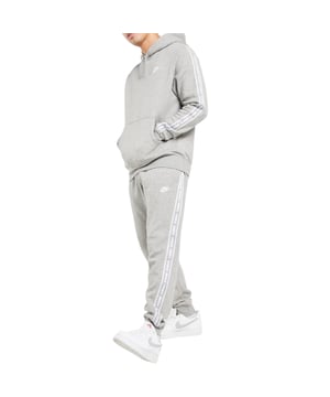 Nike Club Tape GX Suit in Grey Plush 2-piece suit crafted from high-quality, sustainable and breathable materials. Great for training and active leisure. The top half is an overhead hoodie complete with adjustable drawstring hood, rib cuffs and hem, contrast sleeve branding tape, front kangaroo pouch pocket and Nike logo to left chest. The matching bottoms boast an elasticated adjustable drawstring waistband, rib cuffs, open hand pockets and the same matching contrast side tape
