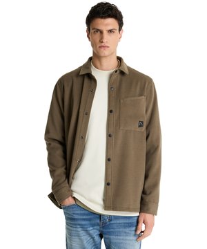 
De Axel Blaze van chasin' is een groen overshirt met een frisse, ingetogen uitstraling dat moeiteloos over een trui of T-shirt draagt. Het satin-achtige samenspel van polyester, viscose en een vleugje elastane geeft het materiaal een zachte structuur die soepel beweegt; de hemdkraag en de knoopsluiting houden het silhouet verzorgd en het normale, boxy model biedt bewegingsvrijheid zonder te groot te lijken. Je merkt aan de borstzak en de nette afwerking dat dit stuk met oog voor detail is gemaakt, en de effen kleur laat andere onderdelen rustig meespelen in je outfit. Door de brushed finish voelt het shirt warm aan en krijgt het een subtiele textuur die uitnodigt om aan te raken, terwijl de normale lengte het gemakkelijk maakt om zowel binnen als buiten te dragen. Het doek valt ontspannen langs het lichaam en accentueert je look zonder op de voorgrond te treden, ideaal voor wie stijl zoekt met subtiele allure. Ons model is 188 cm en draagt maat L, wat helpt inschatten hoe het shirt over je schouders valt. Dit overshirt combineert praktische draagbaarheid met een nette, moderne uitstraling - een kleine upgrade voor je dagelijkse garderobe die zelfvertrouwen geeft.