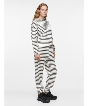 
Dit dames huispak van PIECES combineert een casual everyday-look met het comfort van heerlijk zachte en stretchy jersey stof. Perfect om thuis de hele dag in stijl te loungen. Het shirt heeft elastische manchetten bij de polsen en waistline. De sweatpants is voorzien van een elastische waistband met verstelbare koorden en zijzakken. Zowel het shirt als de sweatpants zijn gemaakt van 50% katoen en 50% polyester.