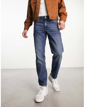 ASOS DESIGN tapered fit jeans i mörk vintage tvätt - MBLUE
