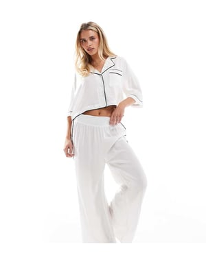 ASOS DESIGN Petite supermjuka slinky vida pyjamasbyxor i vitt med kontrasterande kantband