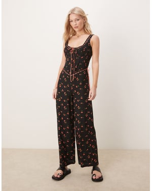 ASOS DESIGN jumpsuit med spetsdetaljer och knäppning framtill, vida ben, i svart körsbärsmönster