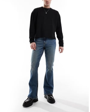 ASOS DESIGN stretch flare jeans i medelblå tvätt