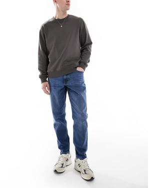 ASOS DESIGN stretch tapered jeans i medtvätt