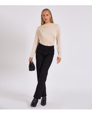 Beige bodysuit med diamantformade örhängen och draperad framsida