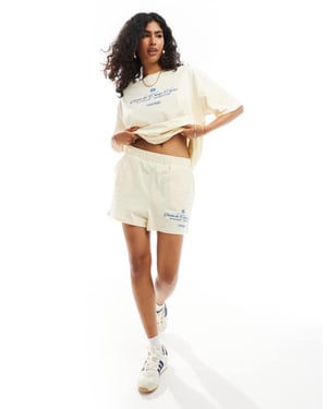 ASOS DESIGN shorts med Champs Élysées grafik i gul