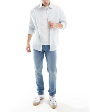 ASOS DESIGN skinny jeans med gul nyans i mellanblå tvätt