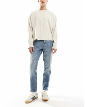 ASOS DESIGN stretch tapered jeans i medtvättad blå