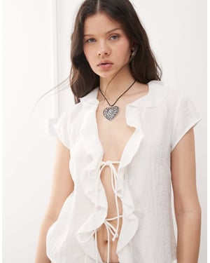 Veckodagsblus med volang och knytning fram i off-white