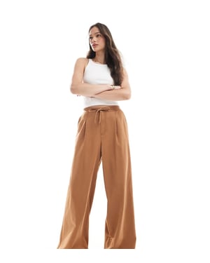 ASOS DESIGN Lång mjuk vida byxor i tvättad karamell