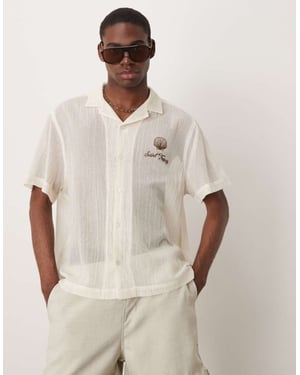 ASOS DESIGN boxig genomskinlig texturerad skjorta med broderi på bröstet i ecru