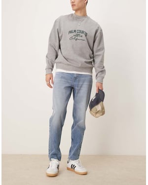 ASOS DESIGN tapered jeans i medelblå tvätt