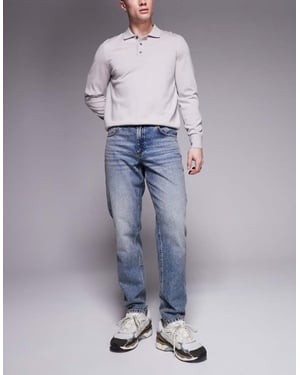ASOS DESIGN tapered fit jeans i medtvättad blå