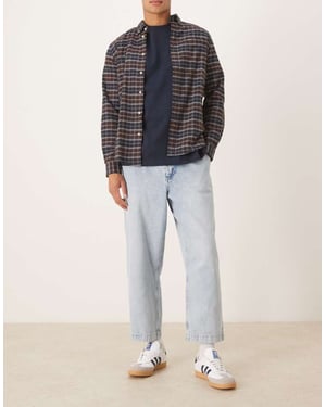ASOS DESIGN avslappnad tapered veckad jeans i blekt tvättat denim