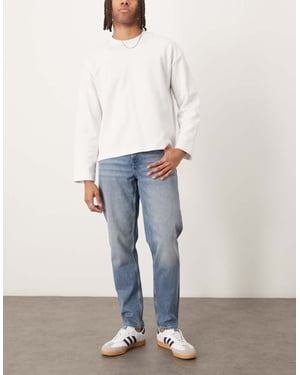 ASOS DESIGN tapered jeans i ljus tvätt blå