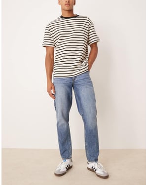 ASOS DESIGN tapered fit jeans i medtvättad blå