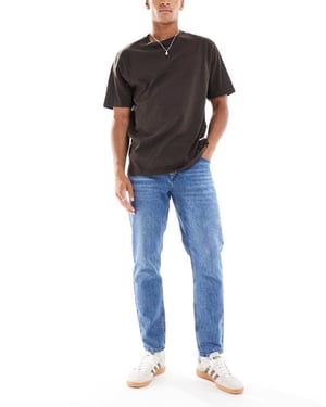 ASOS DESIGN tapered jeans i mid wash blå