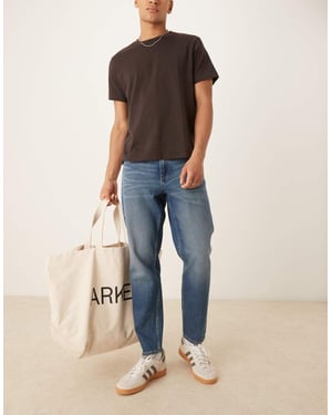 ASOS DESIGN tapered fit jeans med vintagefärg i ljusblå tvätt