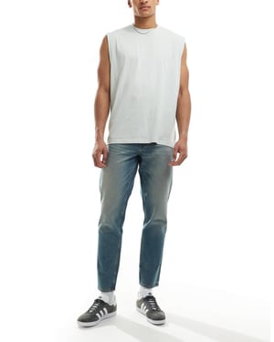 ASOS DESIGN tapered fit jeans med nyans i ljus tvättad blå