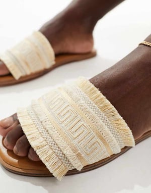 ALDO – Nalani – Guldfärgade platta sandaler med fransar