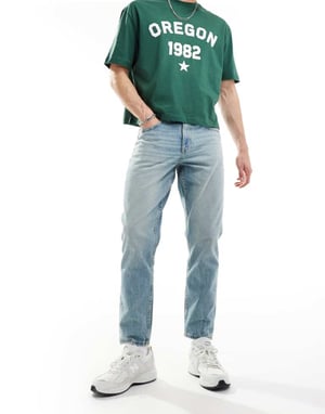 ASOS DESIGN tapered fit jeans med vintagefärg i ljusblå tvätt