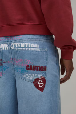 Caution All Over Graphic Tinted Baggy Fit Jeans