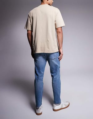 ASOS DSIGN stretch tapered jeans i mellan tvätt med vintageskugga