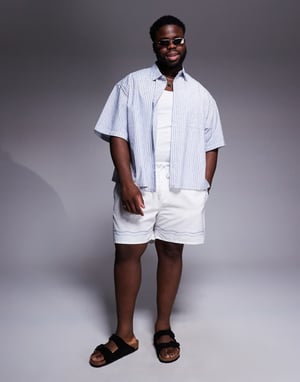 ASOS DESIGN swim shorts in mid length in stone with border print