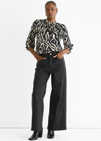 Zwarte satijnen blouse met hoge kraag en dierenprint