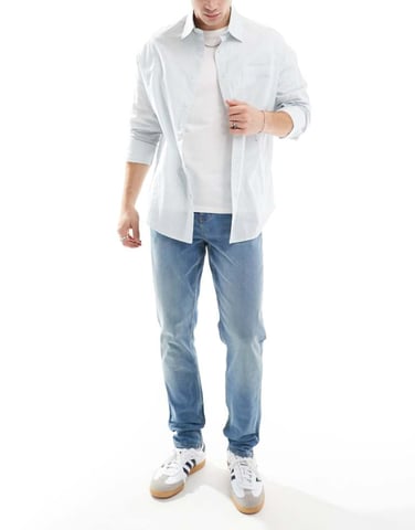 ASOS DESIGN skinny jeans with yellow tint in mid wash blue