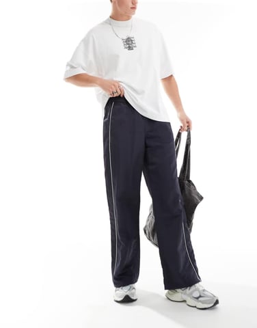 ASOS DESIGN baggy nylon track pants with white piping in navy
