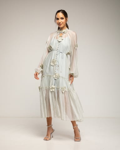 Semi-transparent dress with buttons, floral details, and ruffles. Belt and lining sold separately.